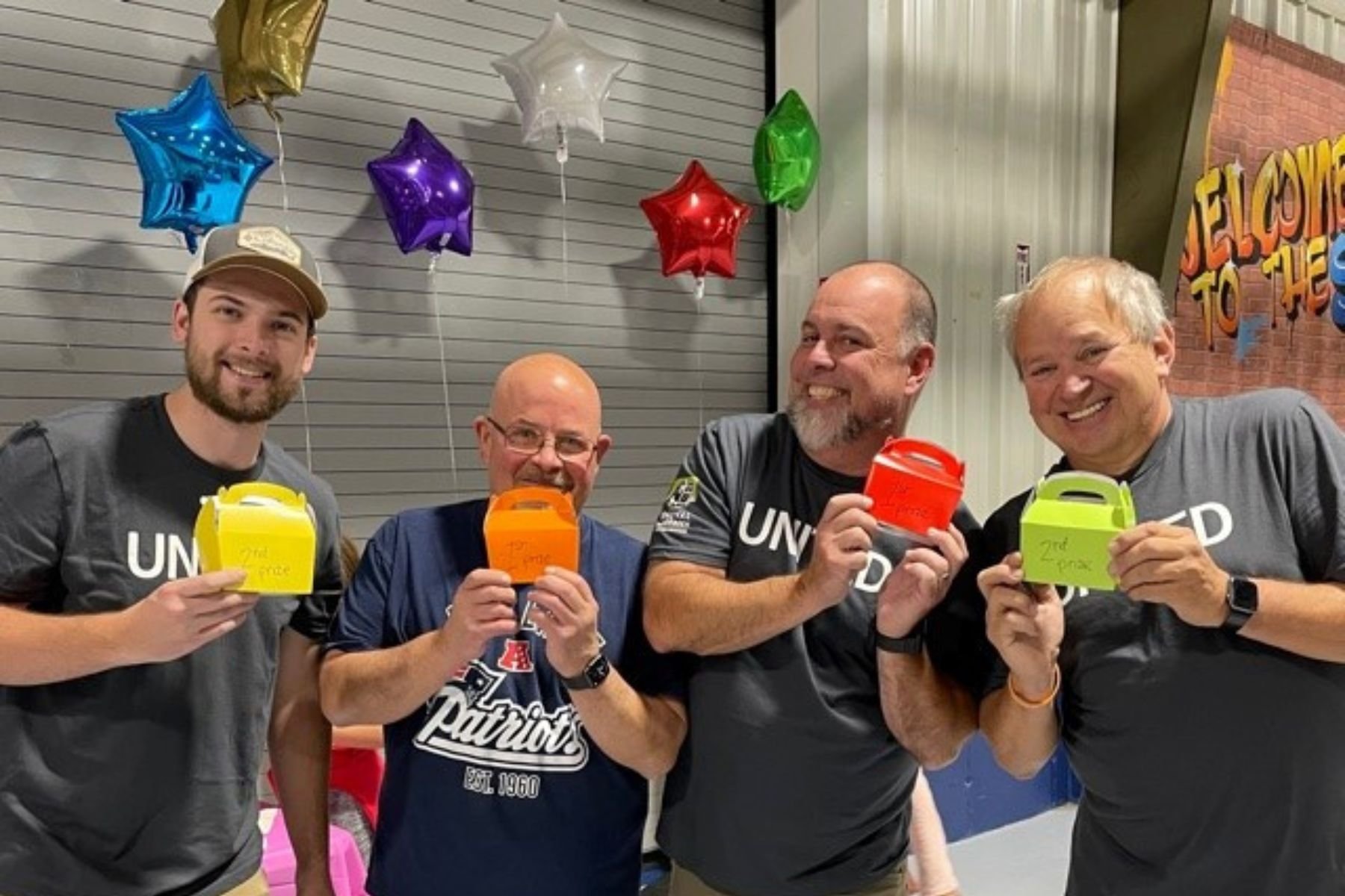 RbA employees showing off prizes during ACS fundraising event.