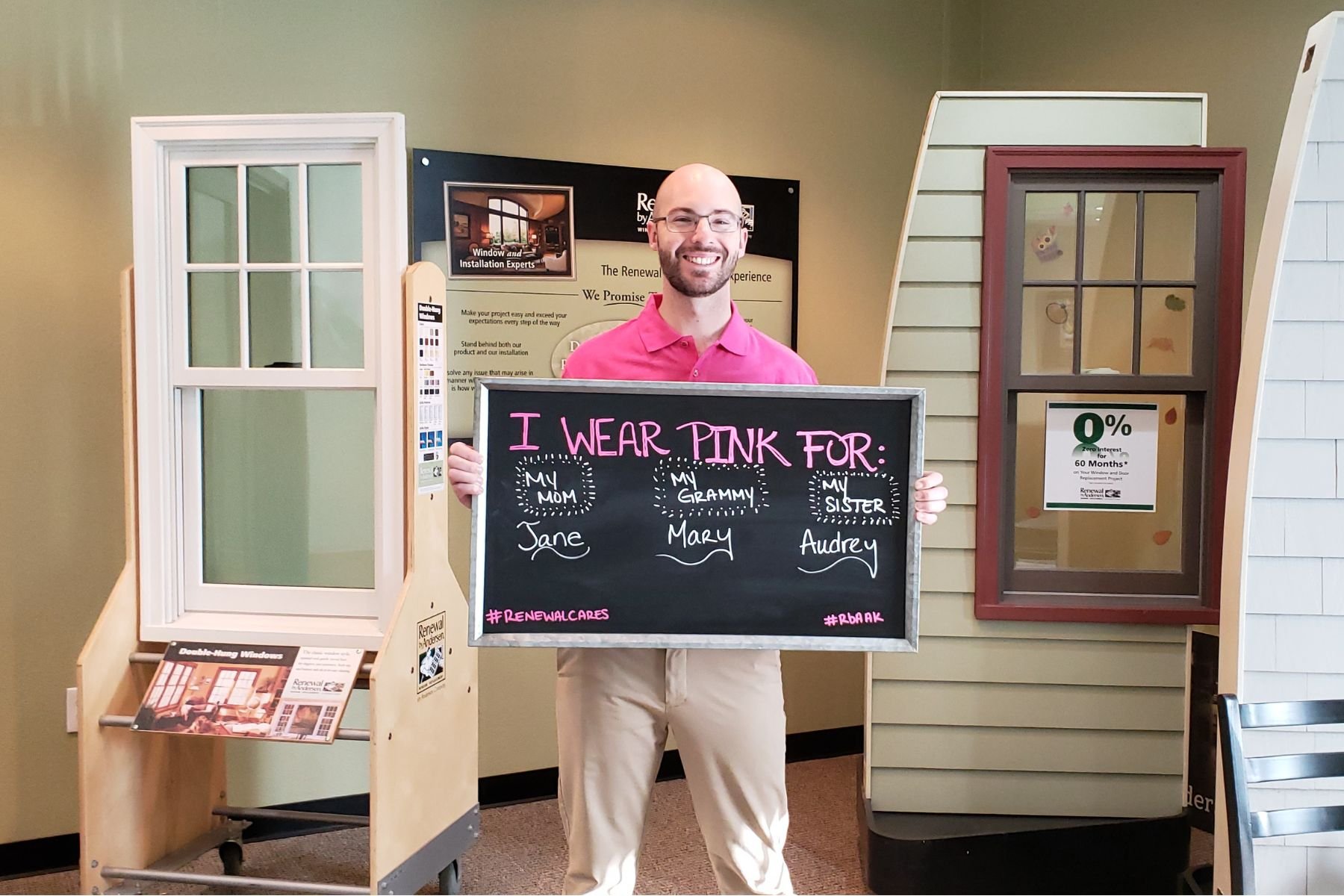 RbA employee holding a sign that reads "I wear pink for...".