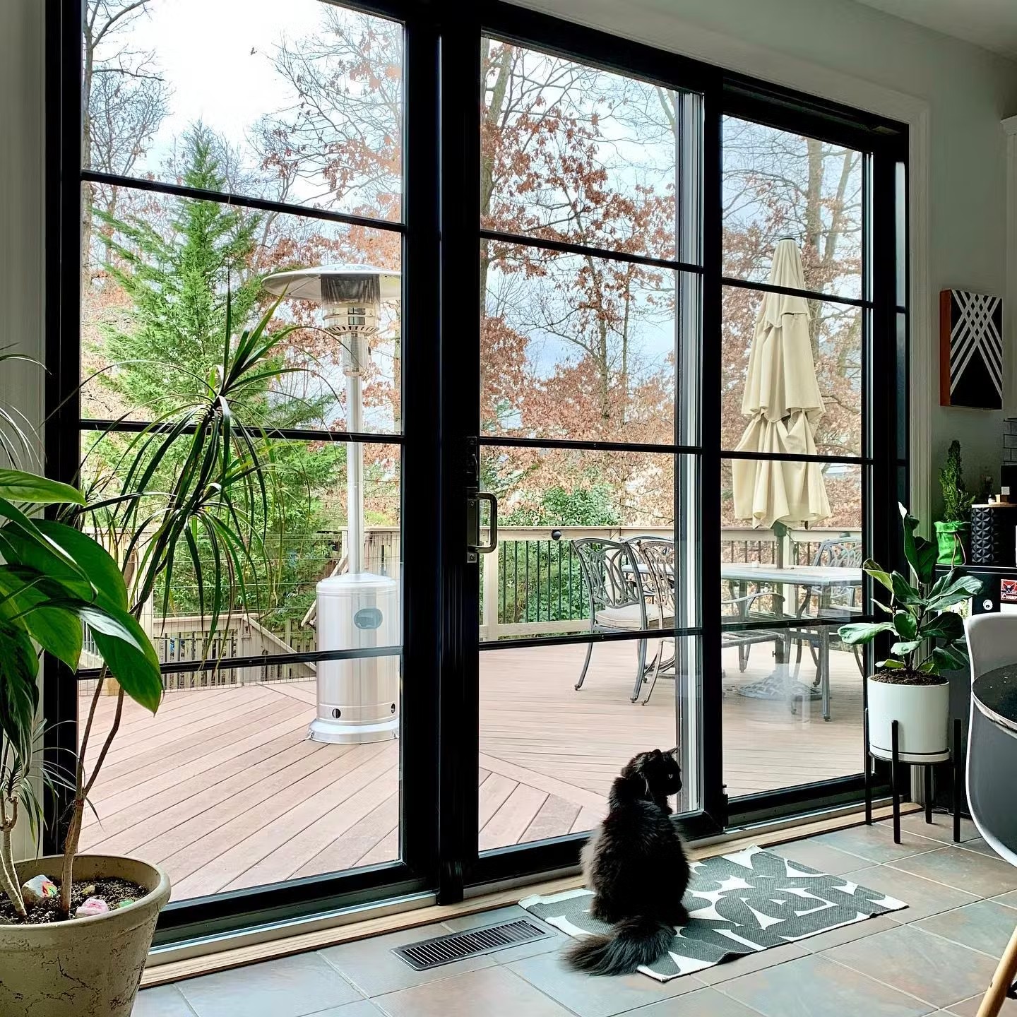 Modern sliding patio doors in a kitchen. These are black permashield doors and have custom grilles. The cat likes to sit by them.