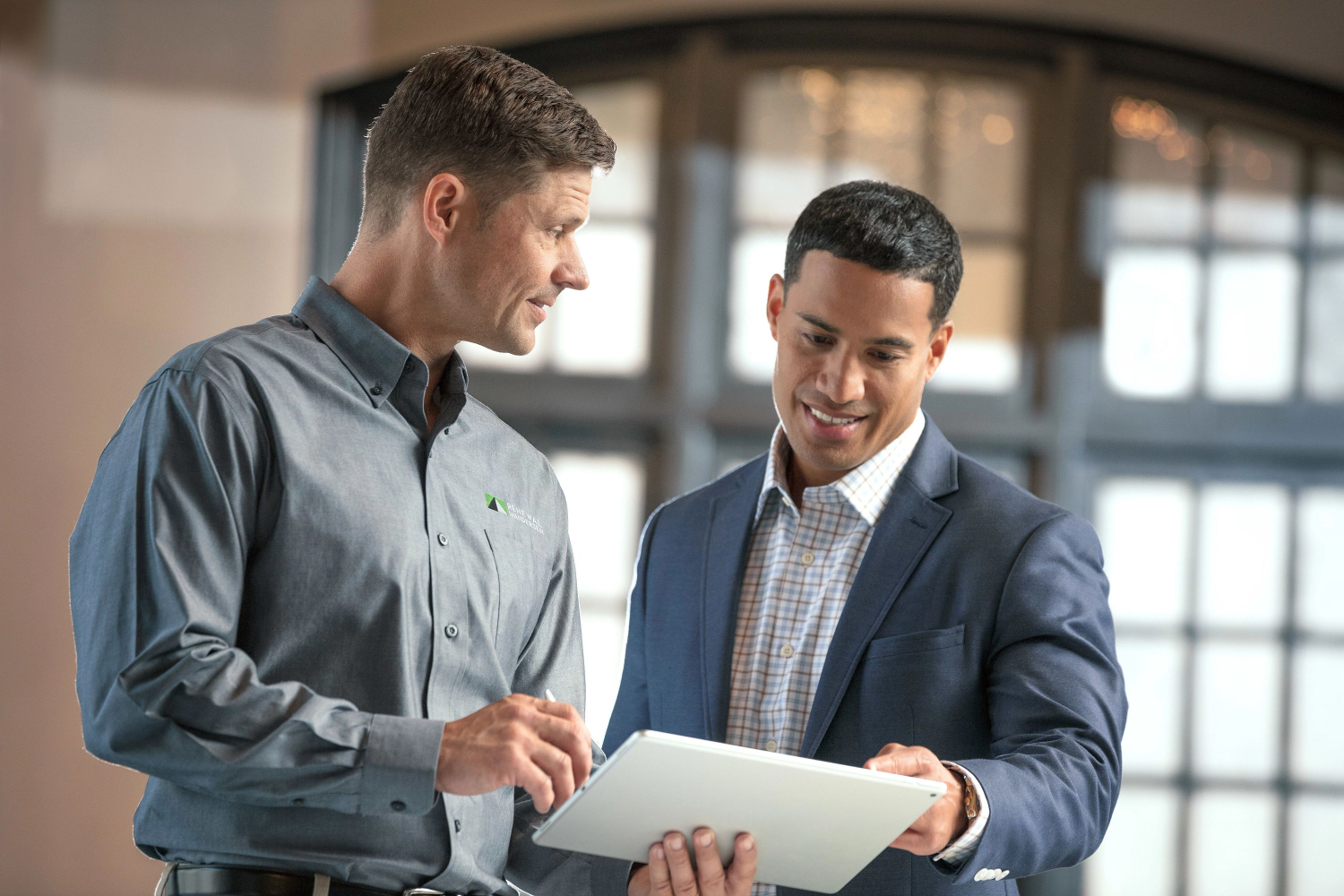 A renewal by andersen consultant working with a potential commercial customer looking over installation plans