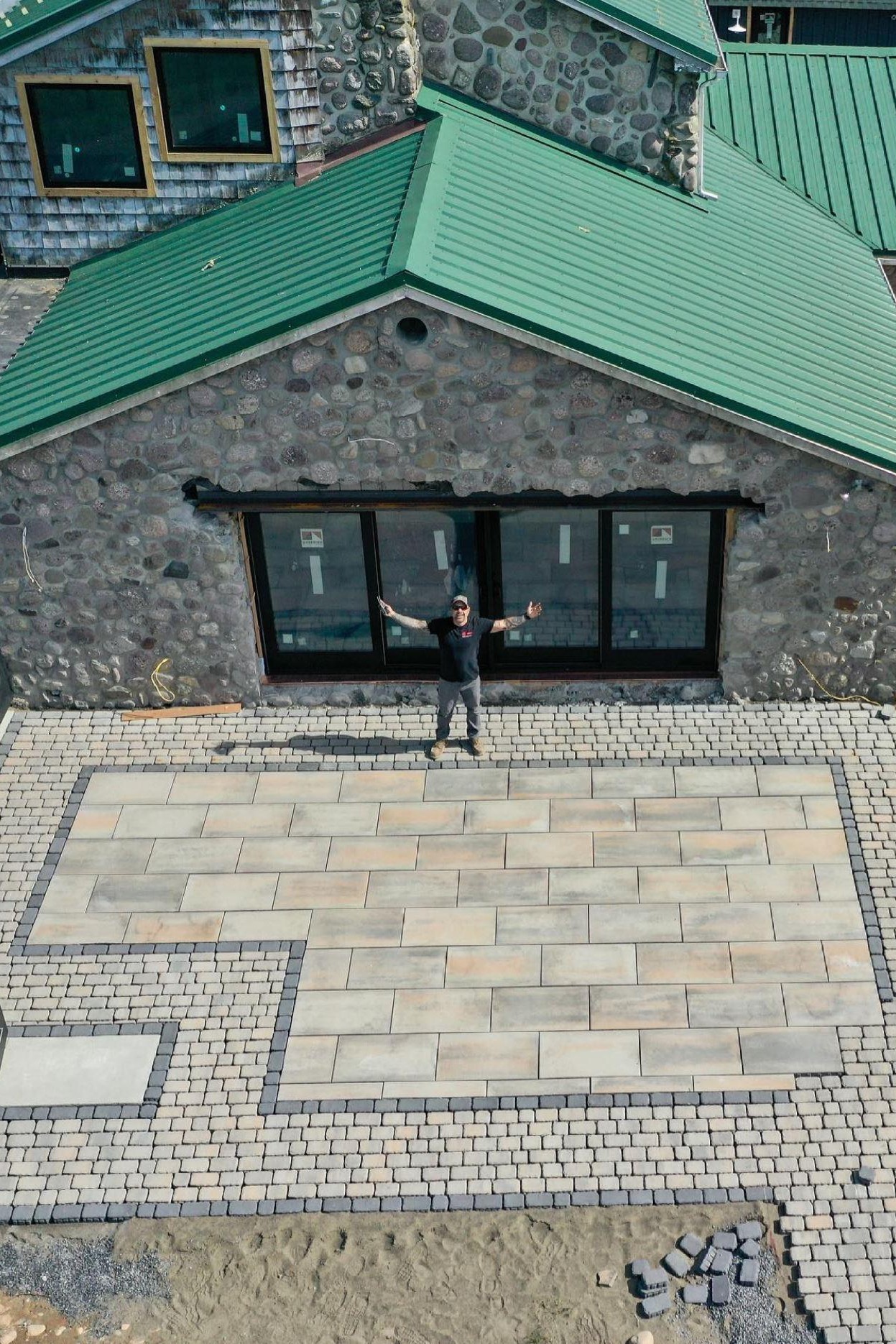 Anthony Carrino stands in front of his stone house looking jubilant.