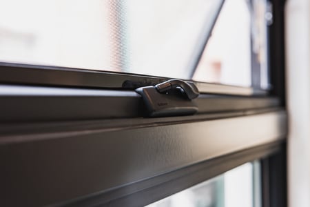 A close up of awning window hardware.