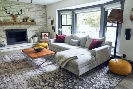 John's bay window inside his living room. He also has a large rug.